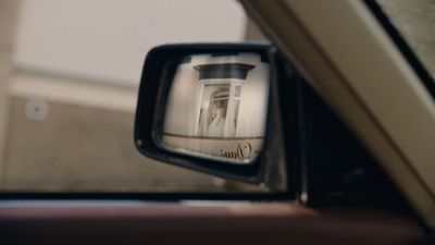 a side view mirror with a picture of a building in it