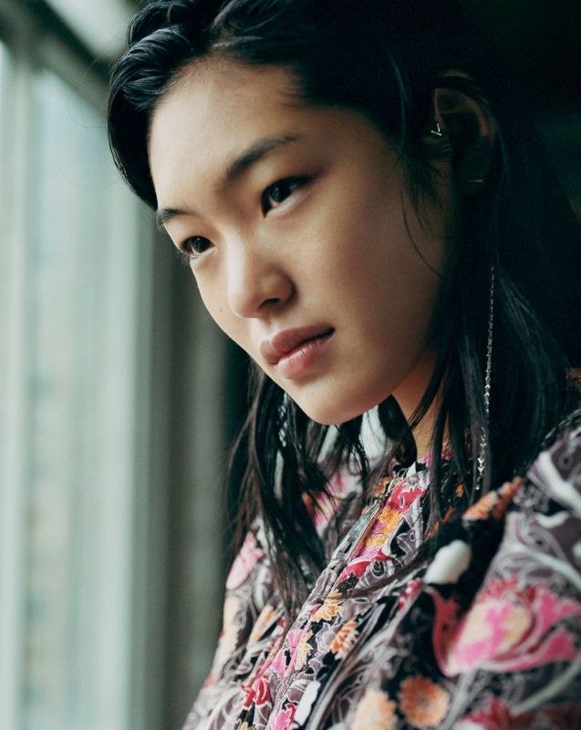 an asian woman looking out of a window