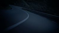 a car driving down a winding road at night