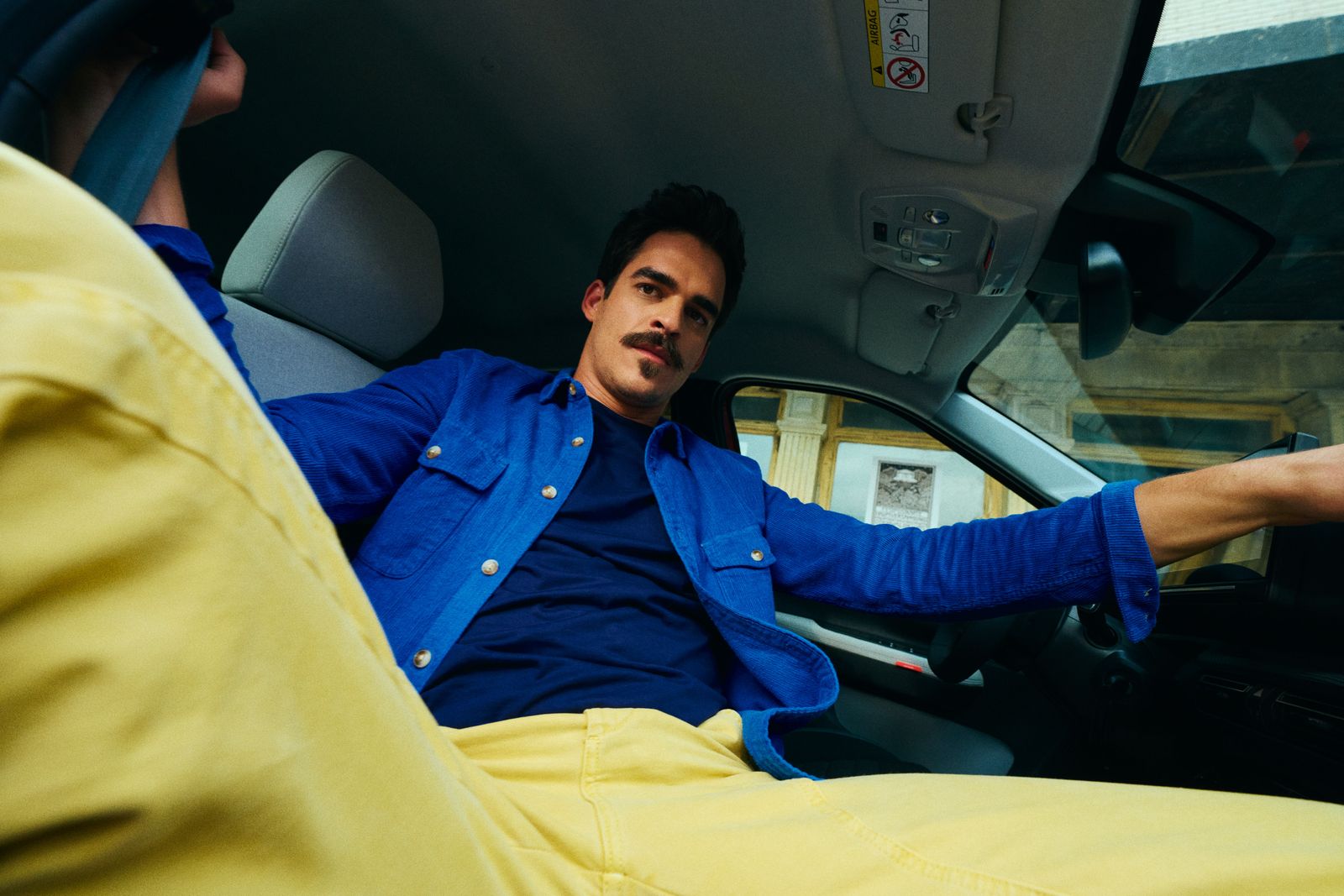 a man sitting in the drivers seat of a car