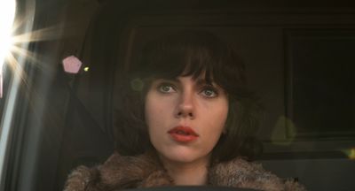 a woman sitting in a car looking out the window