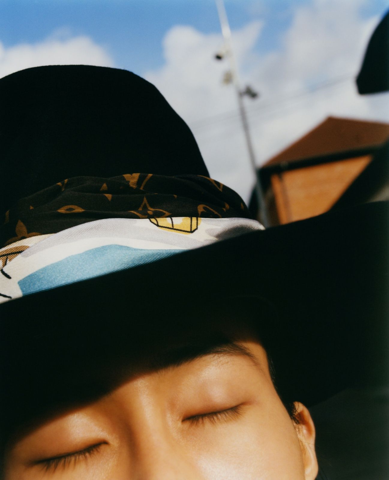 a man wearing a hat with his eyes closed