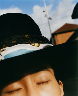 a man wearing a hat with his eyes closed