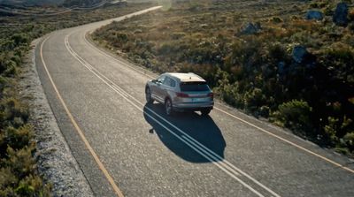 a car driving down a road in the middle of the desert