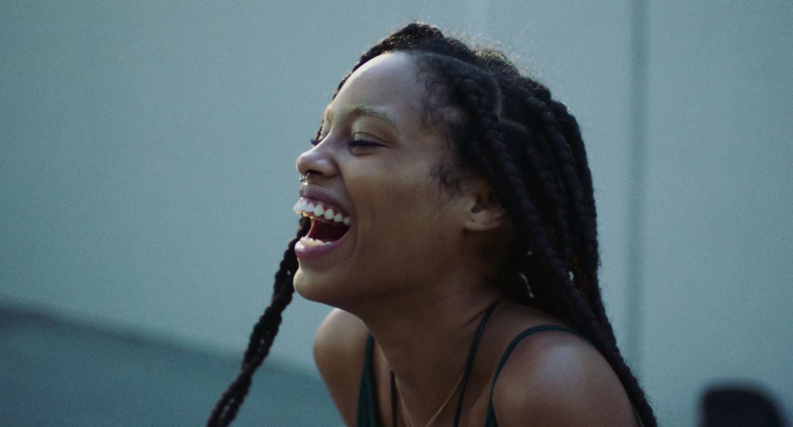 a woman with dreadlocks laughing and looking up