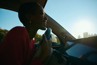 a woman driving a car with a cell phone in her hand