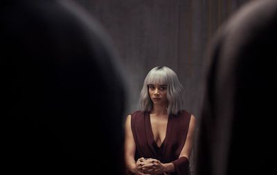 a woman with grey hair standing in front of a mirror