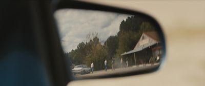 a rear view mirror with a reflection of a building in it