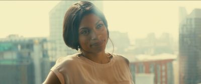 a woman standing in front of a window looking at the camera