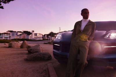 a man standing next to a parked car