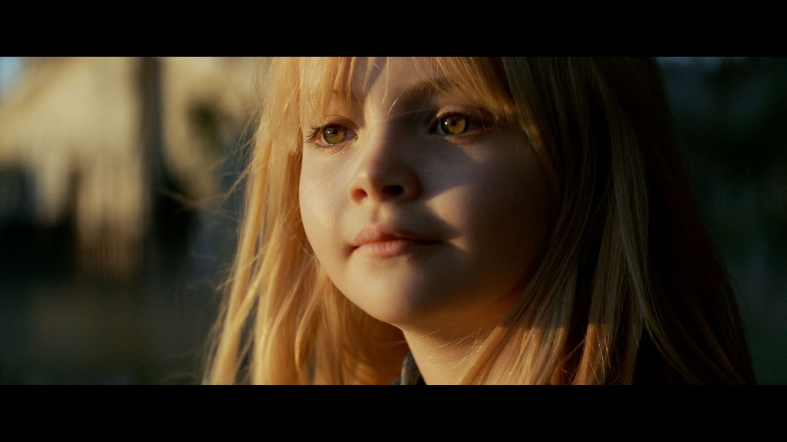 a close up of a child's face with a building in the background