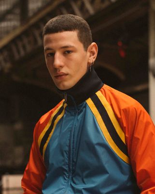 a young man in an orange and blue jacket