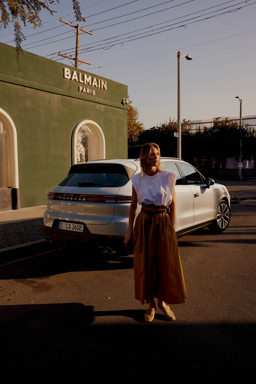 a woman standing in front of a white car