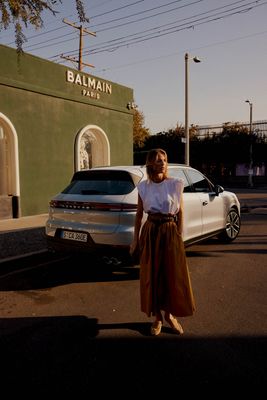 a woman standing in front of a white car