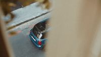 a small blue car parked on the side of the road