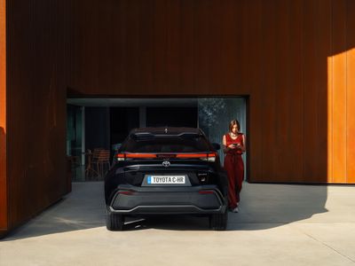 a woman standing next to a car in a garage