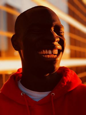 a man in a red hoodie is smiling