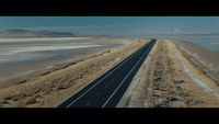 an aerial view of a highway near the ocean