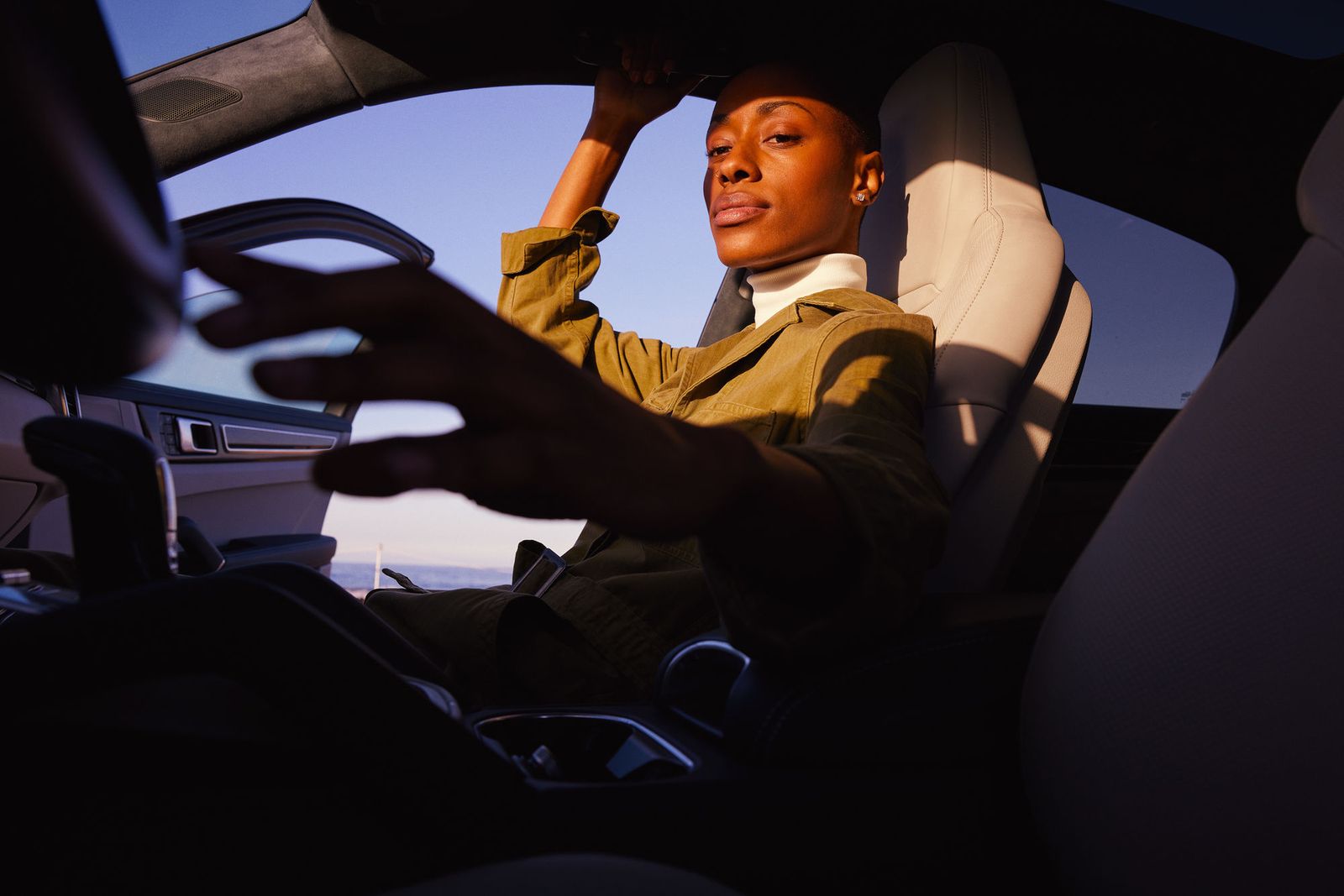 a woman sitting in a car holding a steering wheel