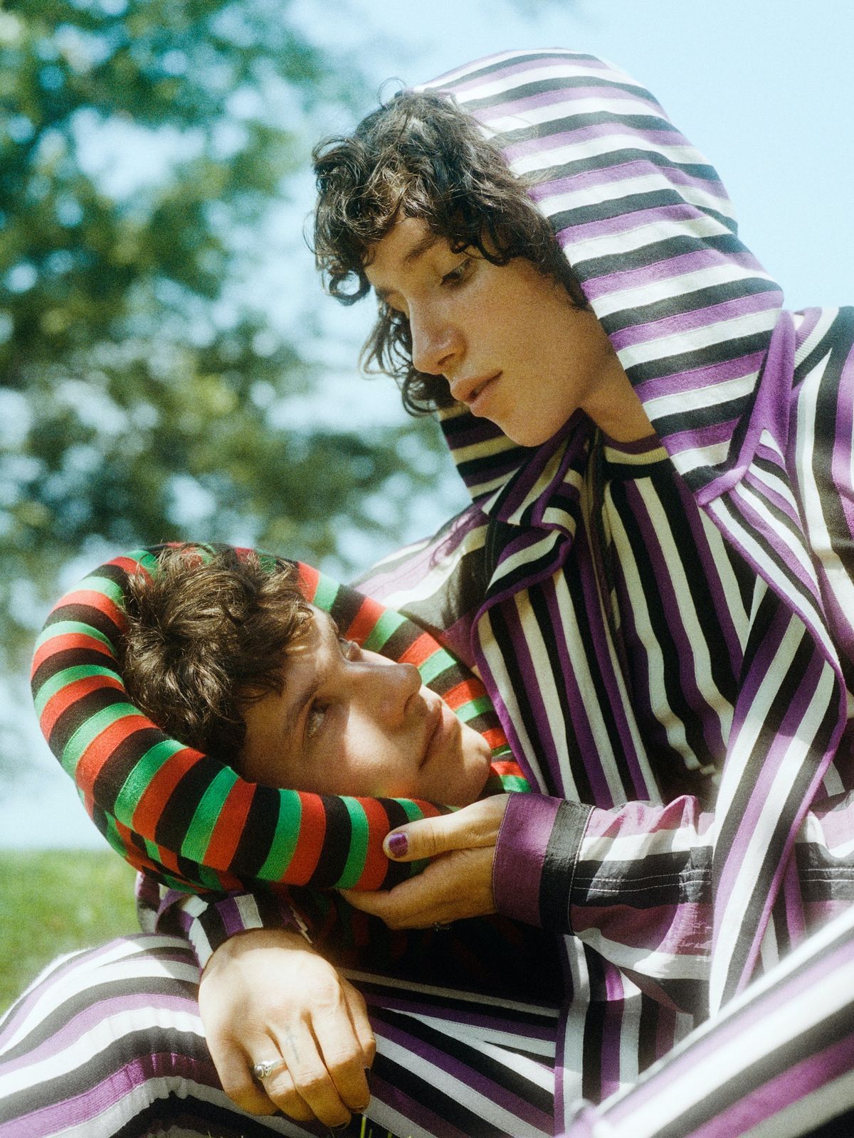 two young men dressed in striped clothing posing for a picture