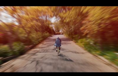 a blurry photo of a person riding a bike down a road