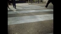 two people walking across a cross walk in the dark