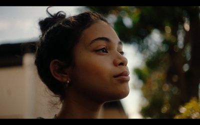 a close up of a person with a tree in the background