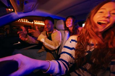 a group of people riding in a car at night