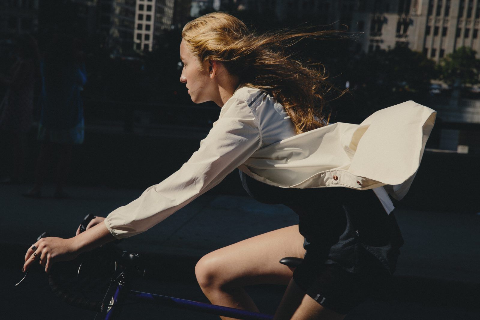 a woman riding a bike down a street