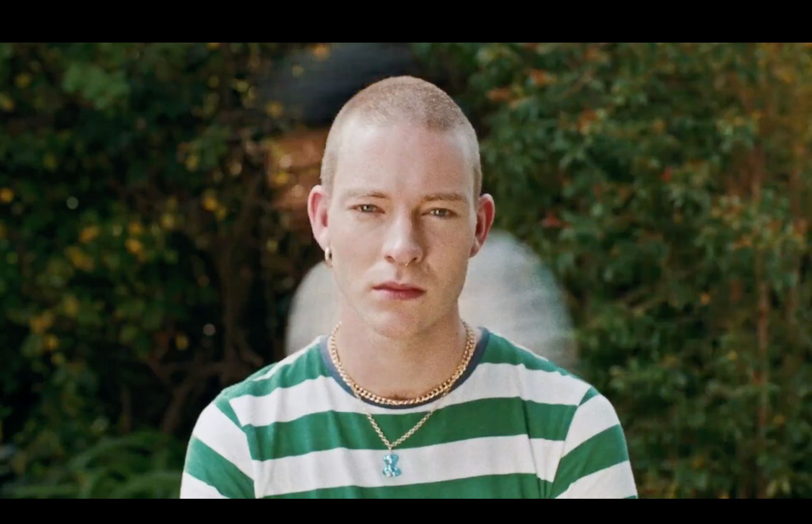 a man with a bald head wearing a green and white striped shirt