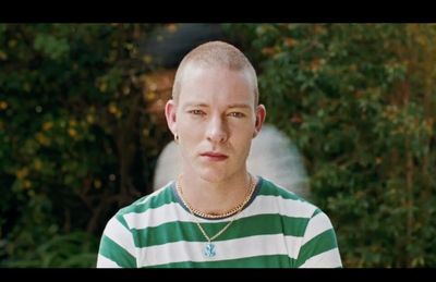 a man with a bald head wearing a green and white striped shirt