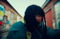 a man with dreadlocks walking down a street