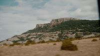 a large mountain with trees on top of it