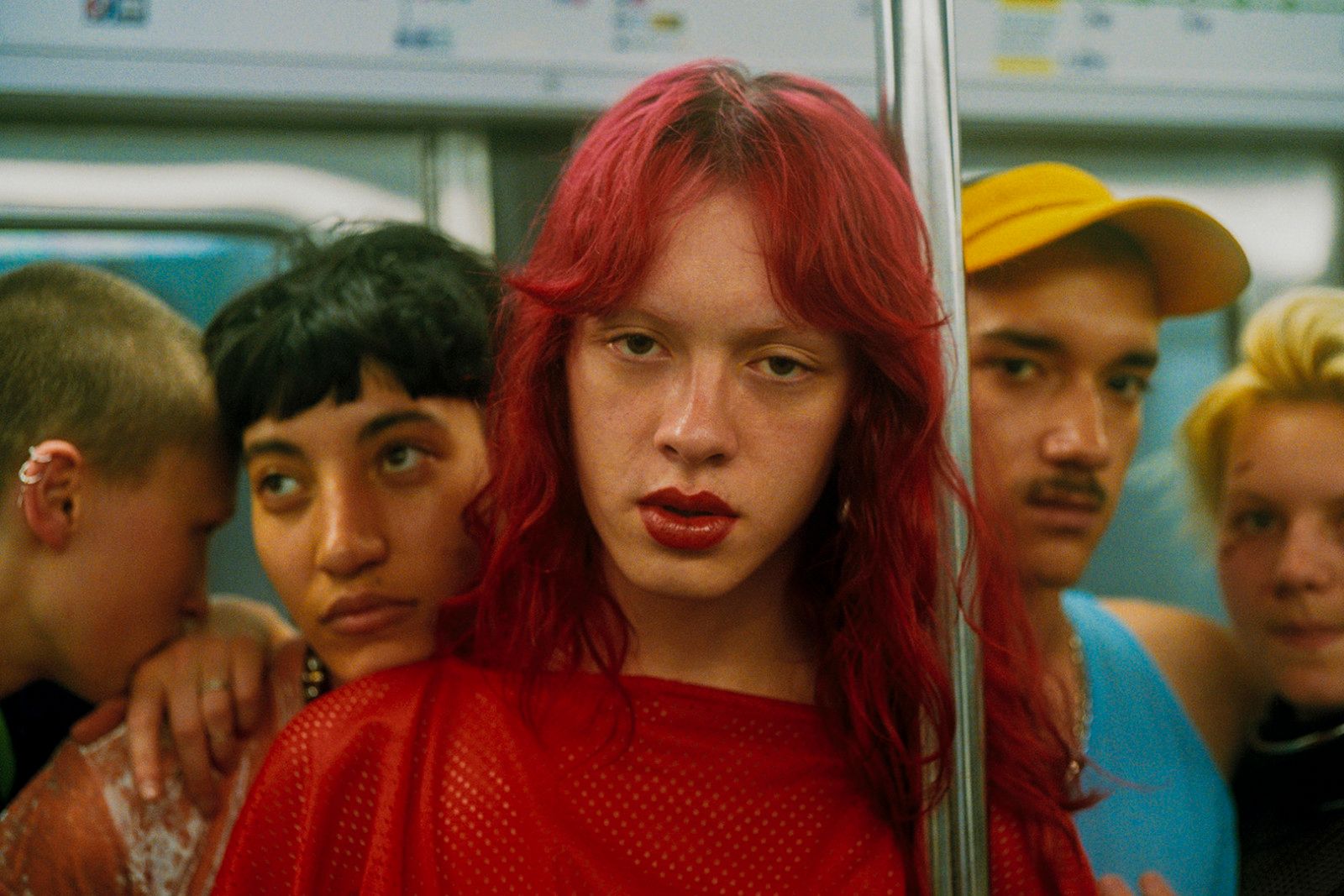 a woman with red hair standing next to a group of people