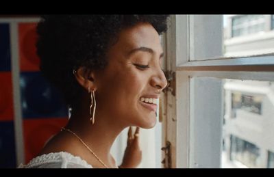 a woman looking out of a window with her eyes closed