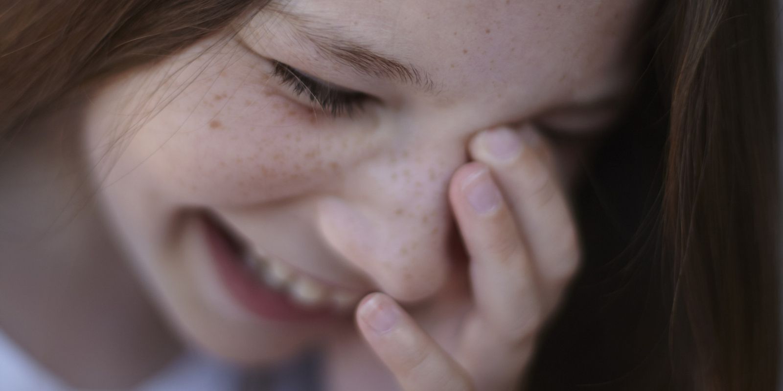 a close up of a person holding their hand to their face