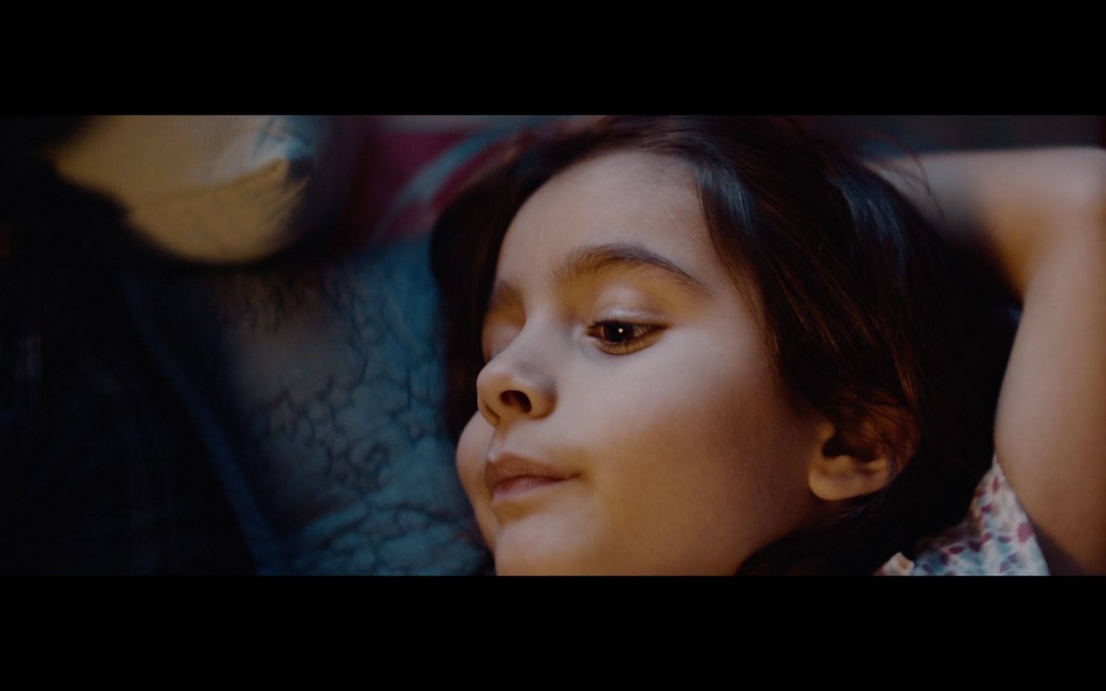 a young girl laying on a couch with her hands behind her head