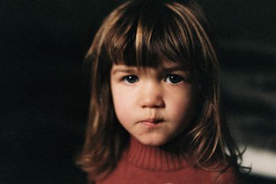 a close up of a child wearing a red sweater