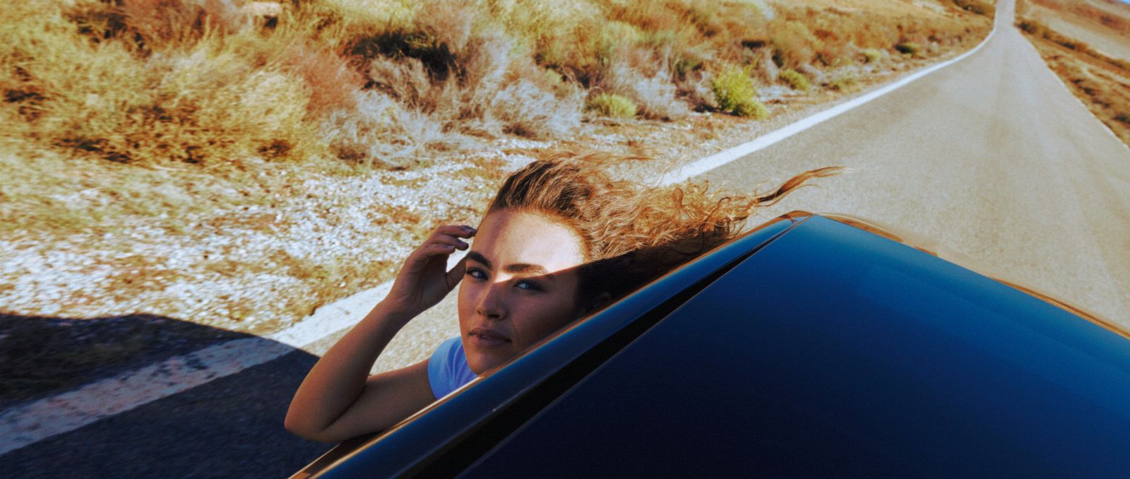 a woman leaning out of a car window