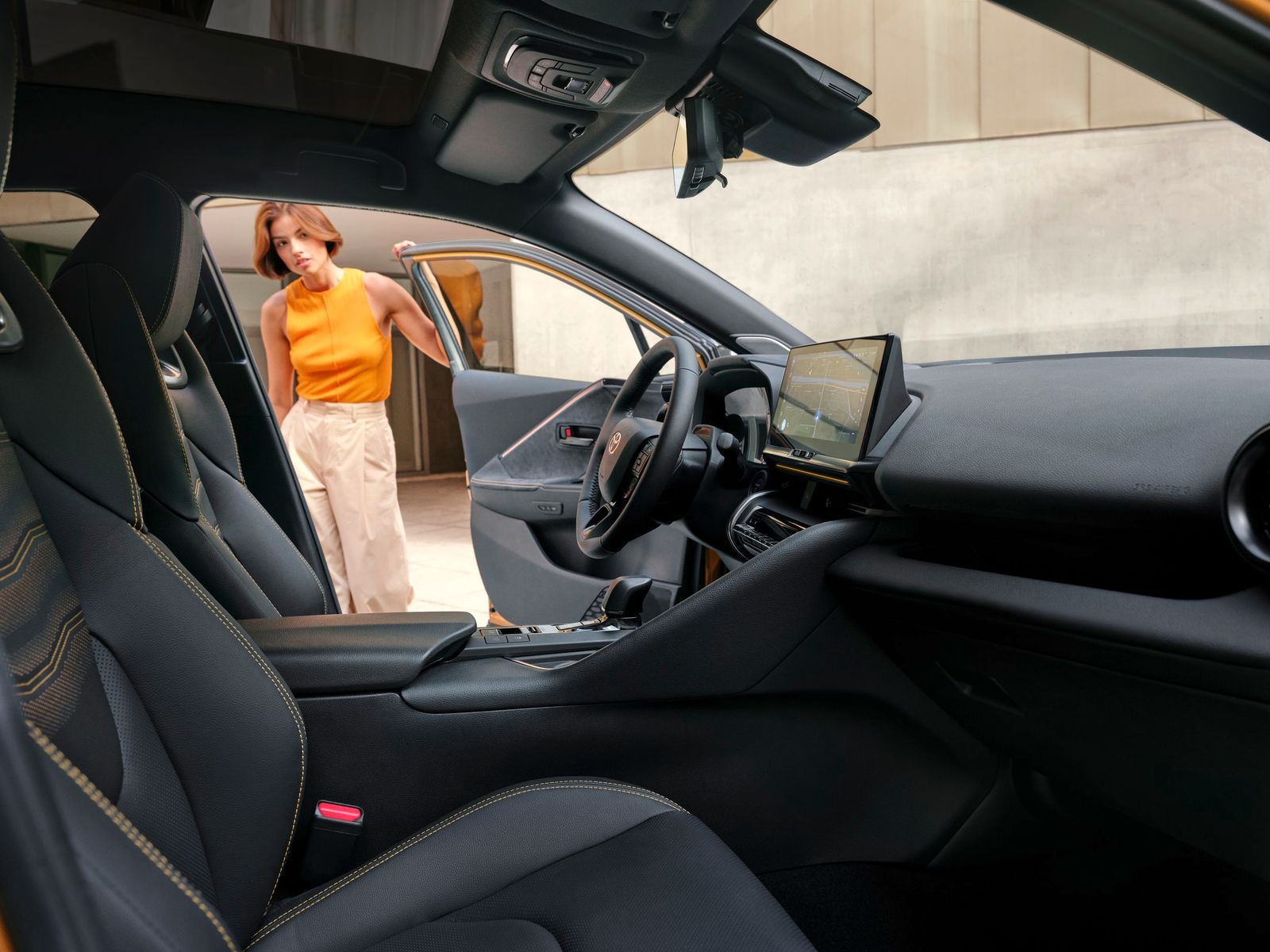 a woman standing in the driver's seat of a car