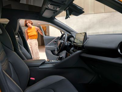 a woman standing in the driver's seat of a car