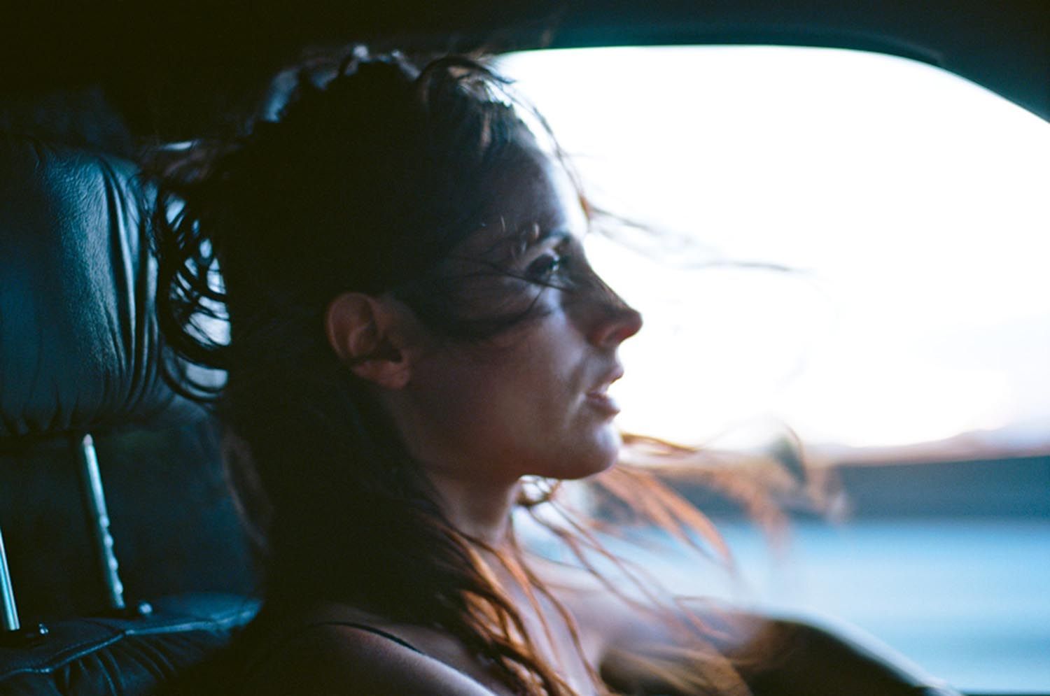 a woman sitting in a car looking out the window