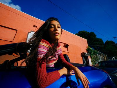 a woman leaning out of a blue car