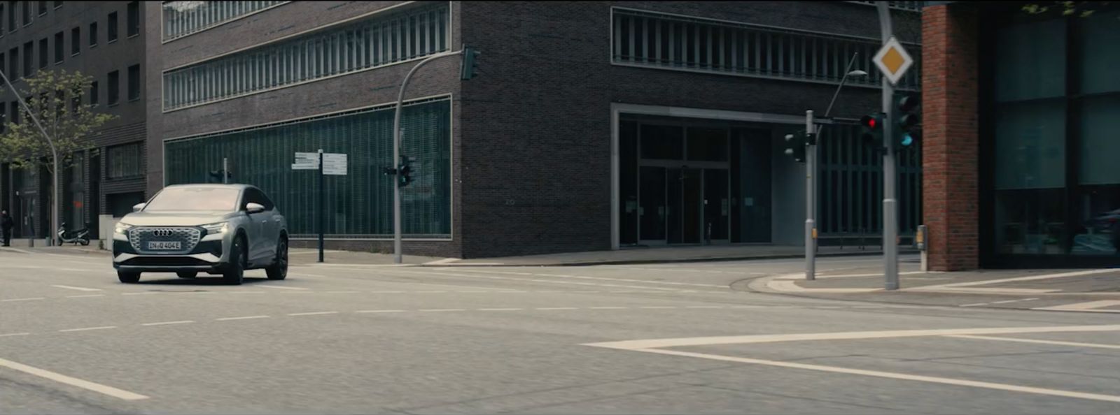 a car driving down a street next to tall buildings