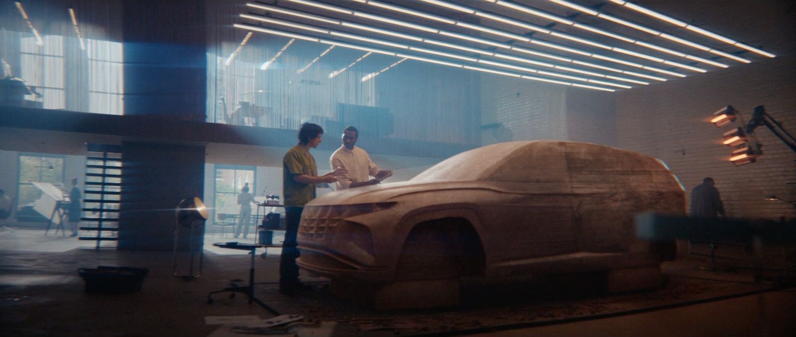 a couple of men standing next to a car