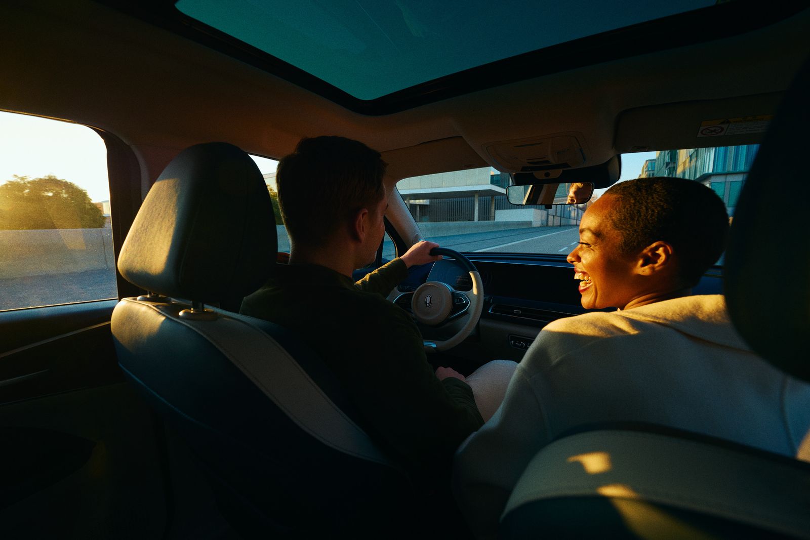 a man driving a car with another man in the passenger seat