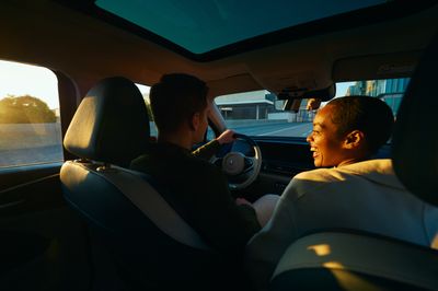 a man driving a car with another man in the passenger seat