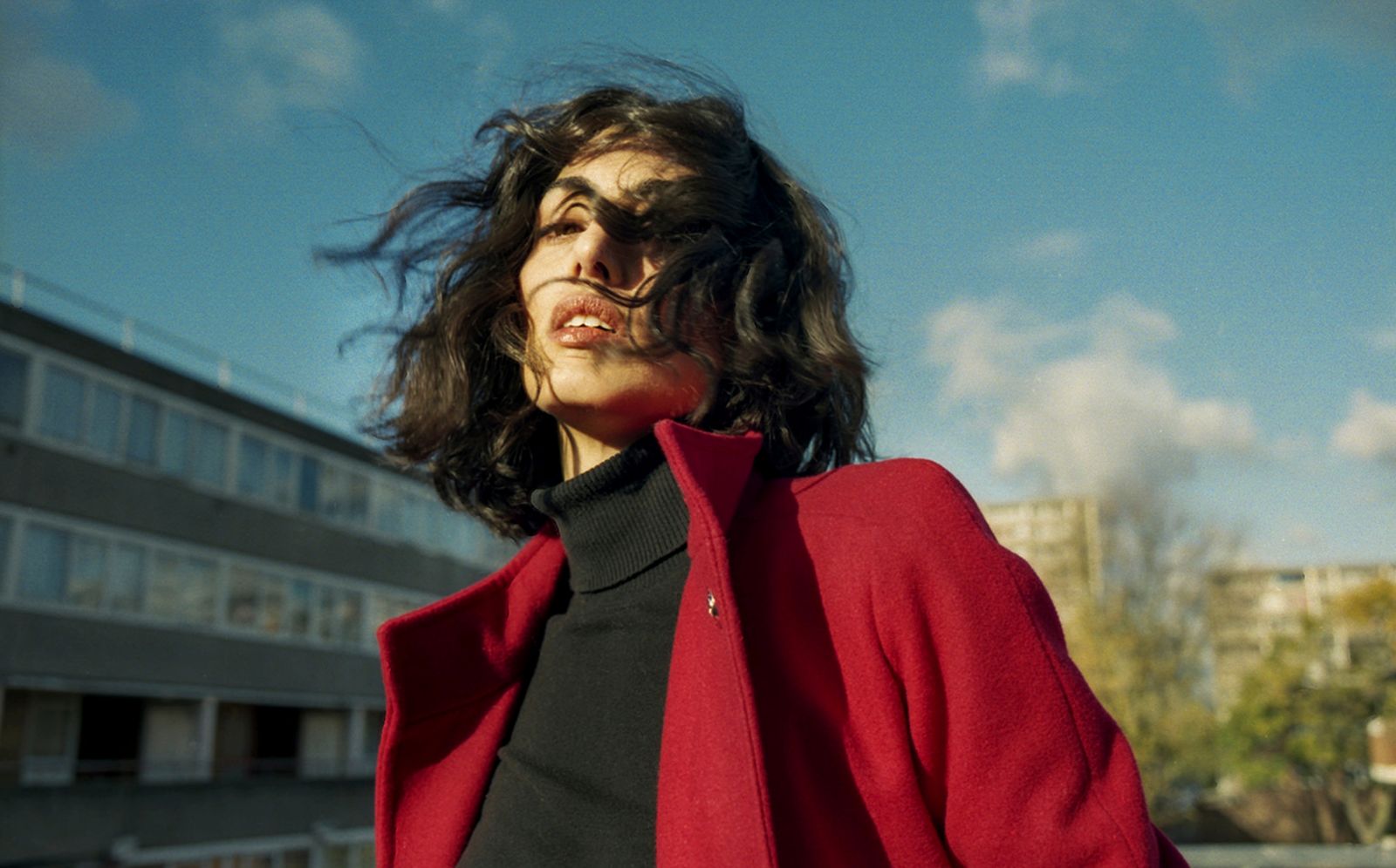 a woman wearing a red coat and black shirt