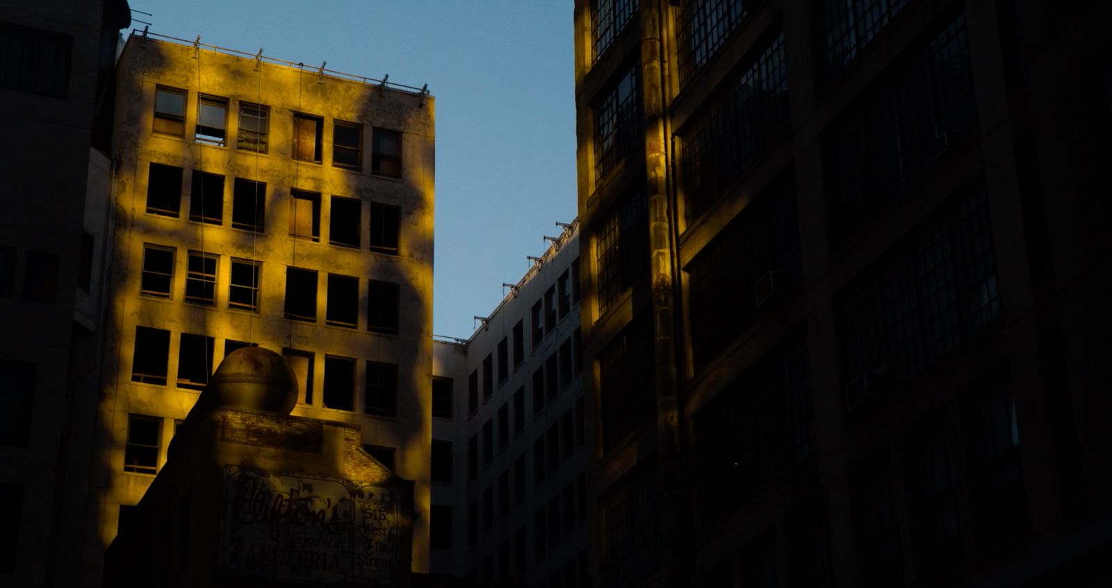 a tall building with lots of windows next to other buildings