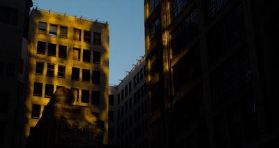 a tall building with lots of windows next to other buildings